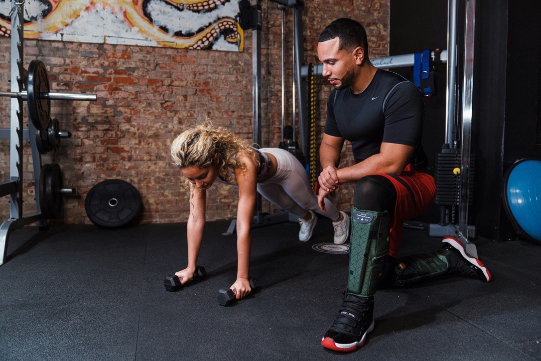 Trainer guiding a client through an exercise